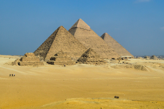 Three short pyramids sit in front of three much larger pyramids in the desert