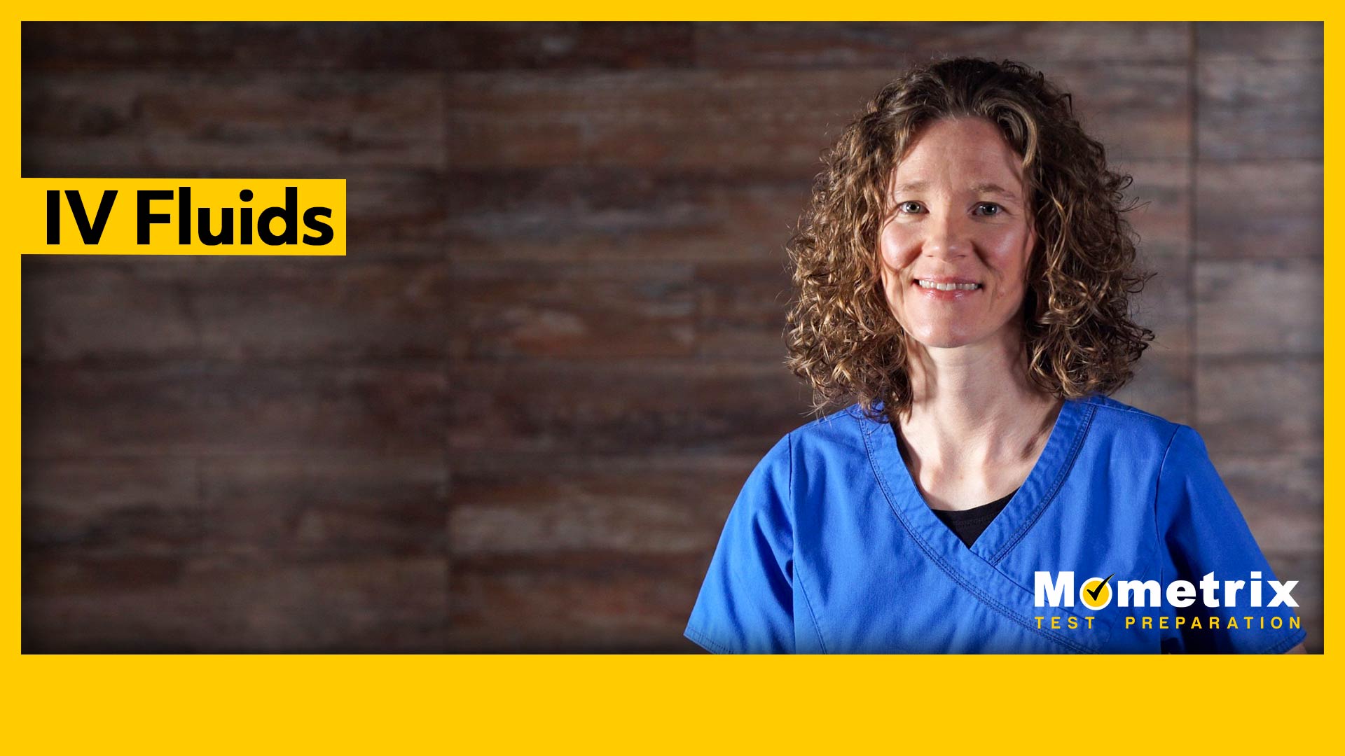 A person with curly hair in a blue medical scrub top stands smiling in front of a wooden wall with the text "IV Fluids" and "Mometrix Test Preparation.